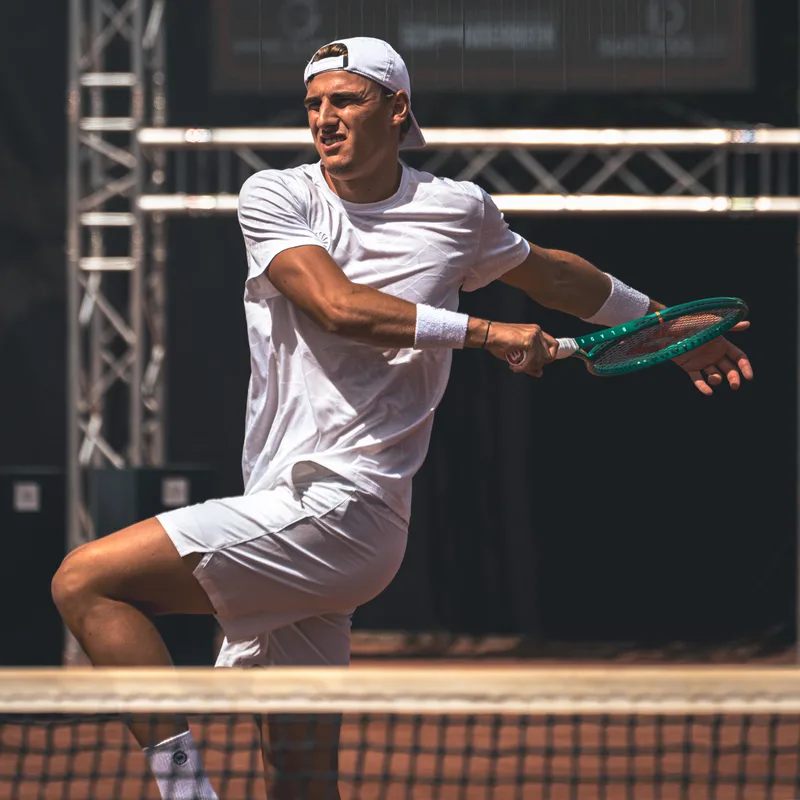 Speler slaat een backhand vlak achter het net