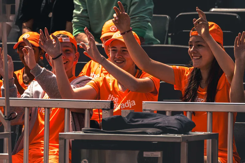 Ballenkinderen in oranje juichen langs de baan tijdens het toernooi
