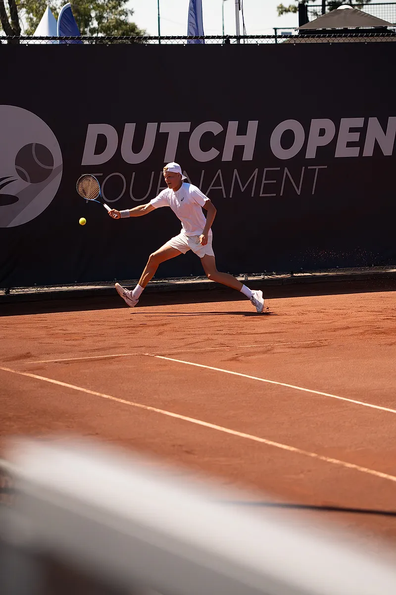 Speler strekt zich in een lunge naar de return