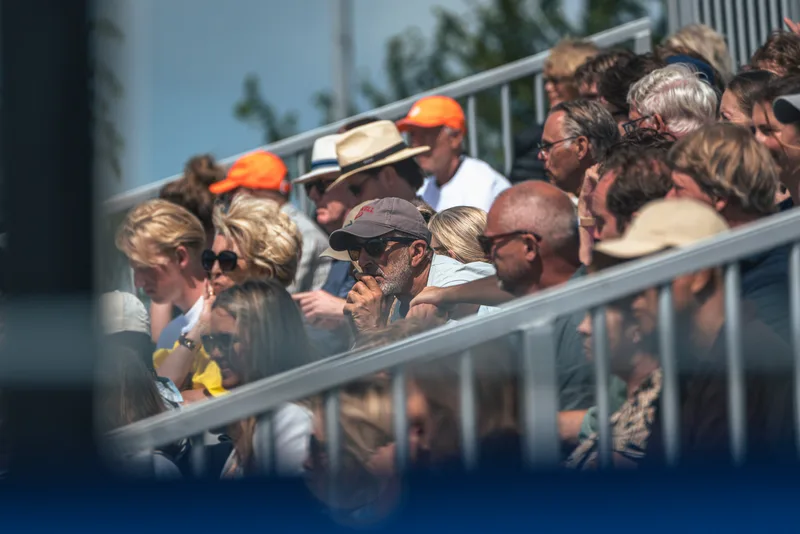 Publiek met oranje petten op de volle tribune van het Dutch Open Tournament