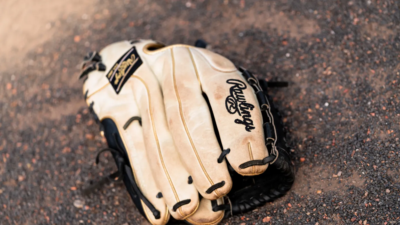 Rawlings softball glove on the infield dirt — detail photography by 7EMPLE Netherlands