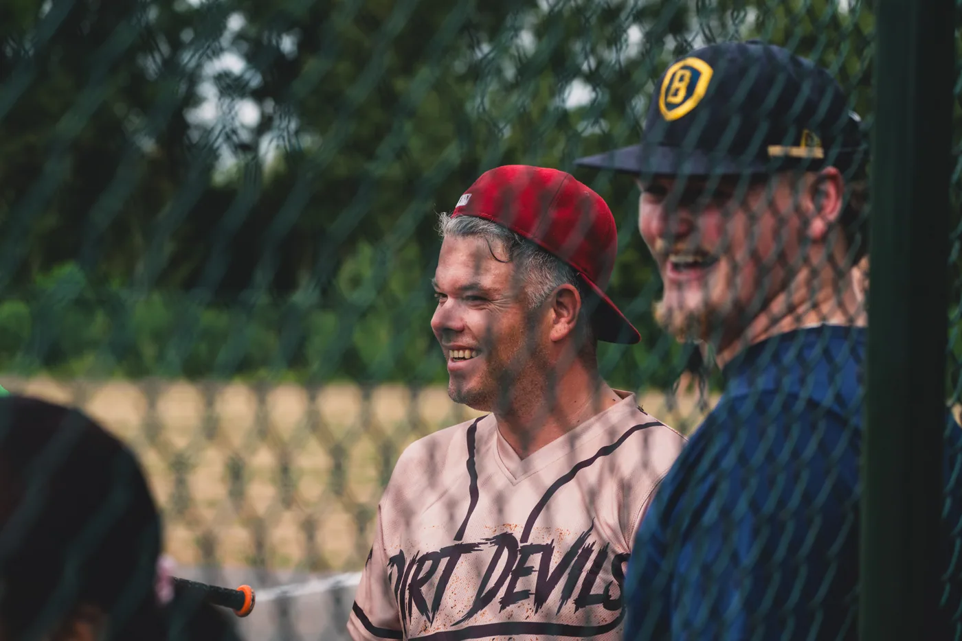 Twee spelers lachen samen langs de zijlijn