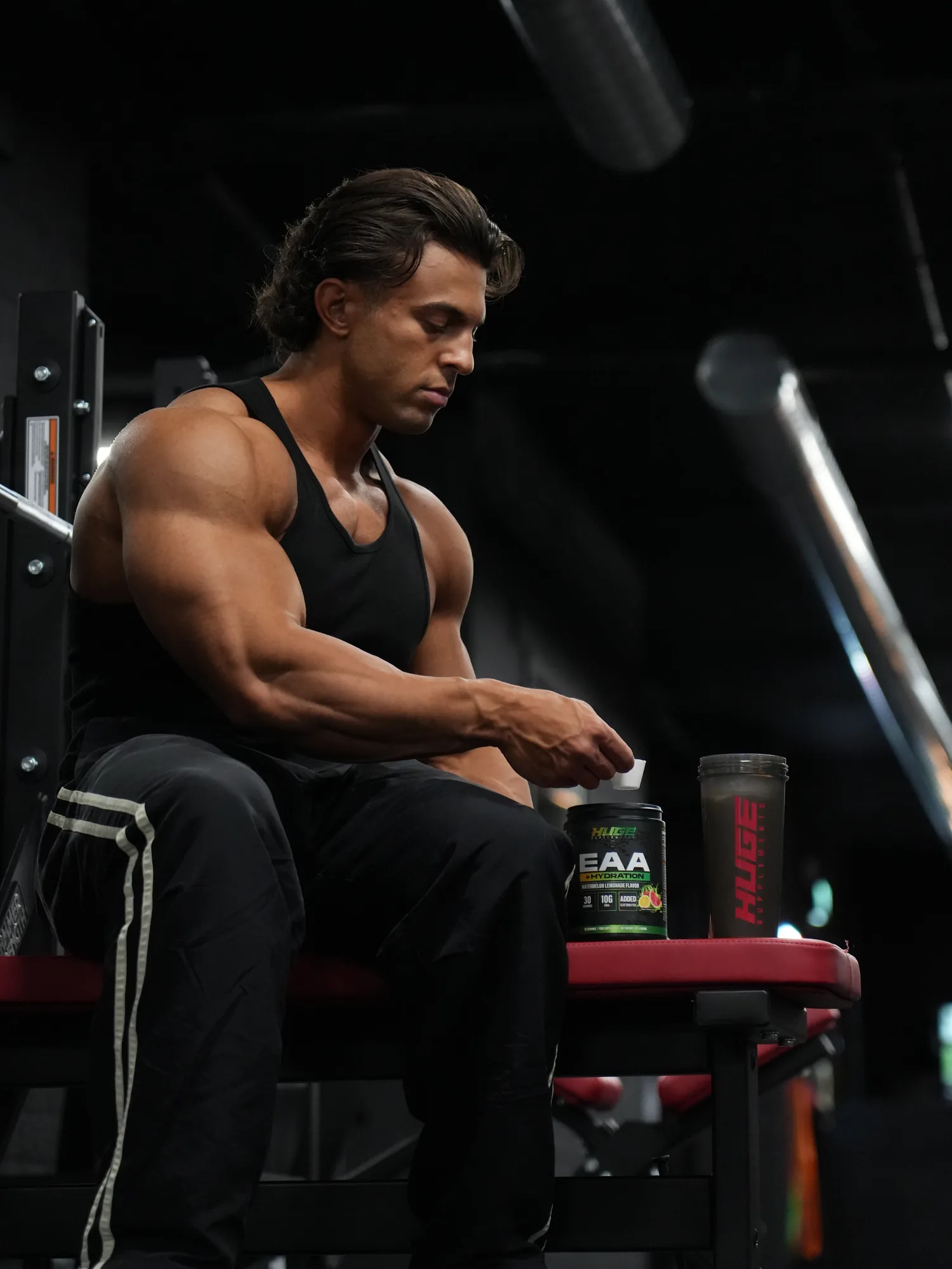 Chakir seated with Huge Supplements EAA and shaker — product detail