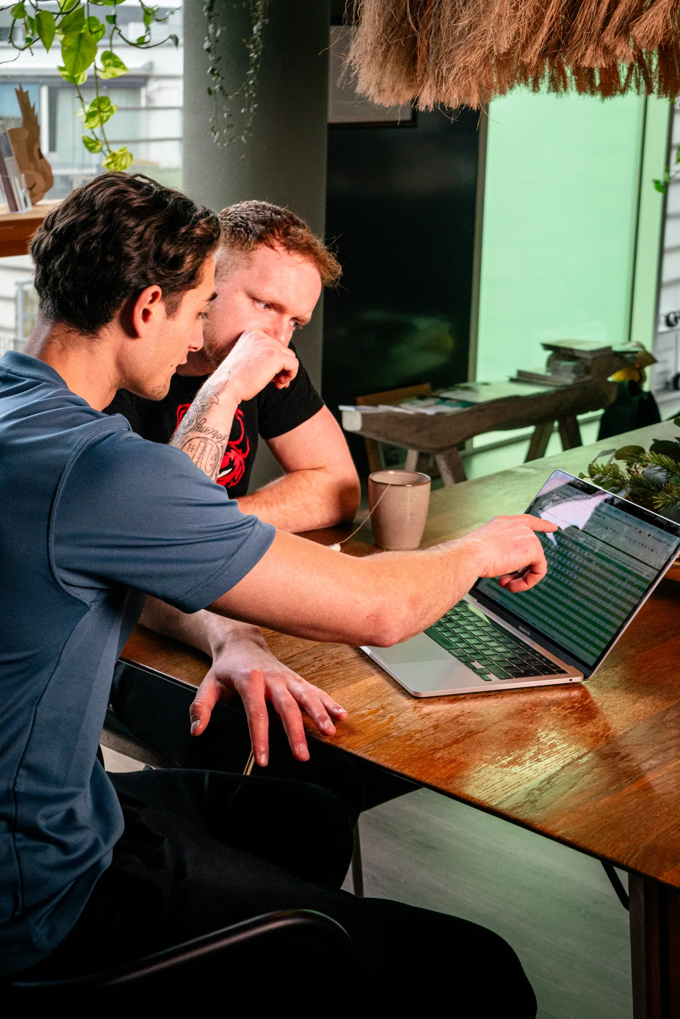 Nino trainer and client reviewing training program on laptop — brand photography by 7EMPLE