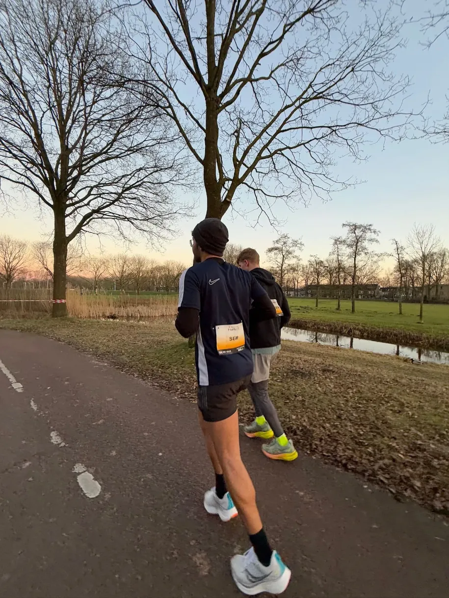 Sem Koopman running with race bib at dawn along Dutch waterway — ultramarathon documentary by 7EMPLE